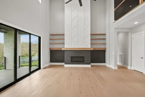 an empty room with floor to ceiling window and stairs