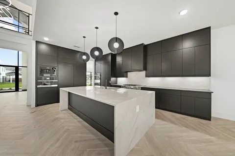 a large kitchen with kitchen island a sink stainless steel appliances and cabinets