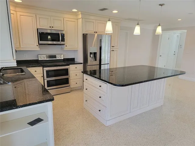 a kitchen with stainless steel appliances a stove a microwave and a refrigerator