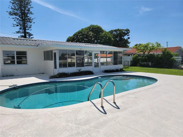 a view of a house with a swimming pool and sitting area