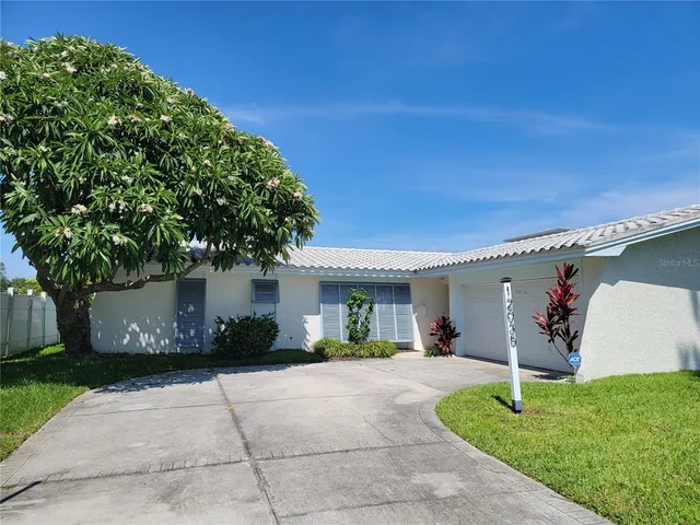 a view of a house with backyard and a tree