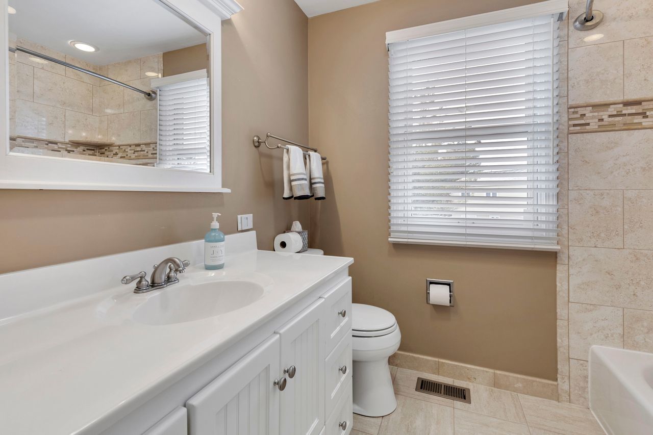 681 Randi Lane Hoffman Estates, IL 60169 - Photo 22 of 33 a bathroom with a sink a toilet and a mirror