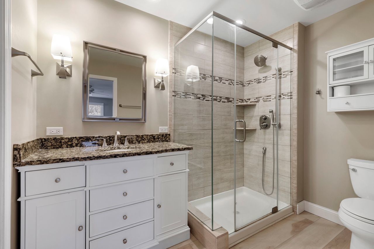 681 Randi Lane Hoffman Estates, IL 60169 - Photo 25 of 33 a bathroom with a granite countertop sink a toilet and shower