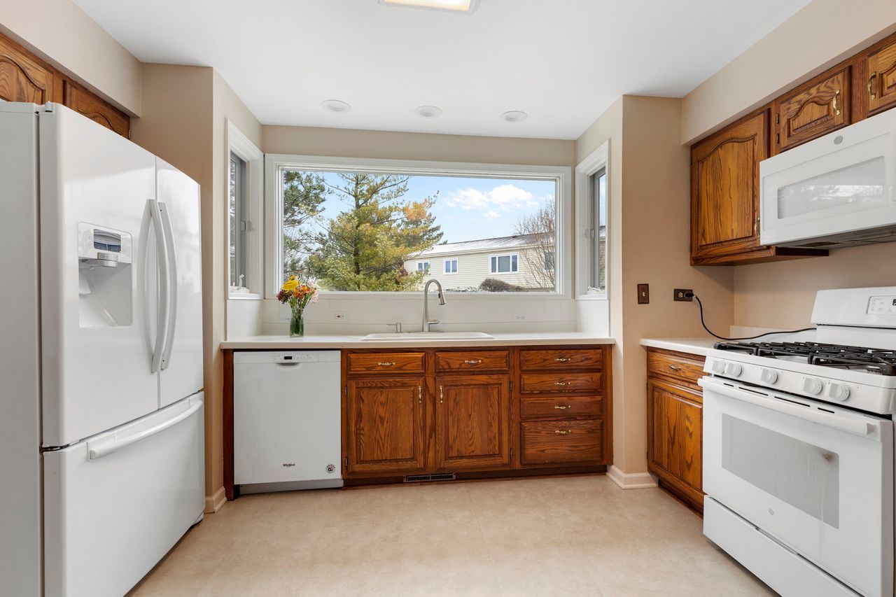 681 Randi Lane Hoffman Estates, IL 60169 - Photo 3 of 33 a kitchen with granite countertop white cabinets and white appliances