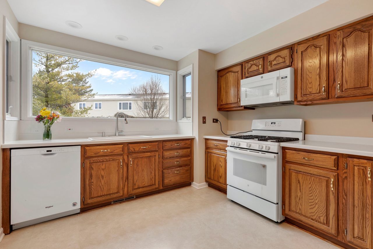 681 Randi Lane Hoffman Estates, IL 60169 - Photo 4 of 33 a kitchen with stainless steel appliances granite countertop a stove a sink and a microwave
