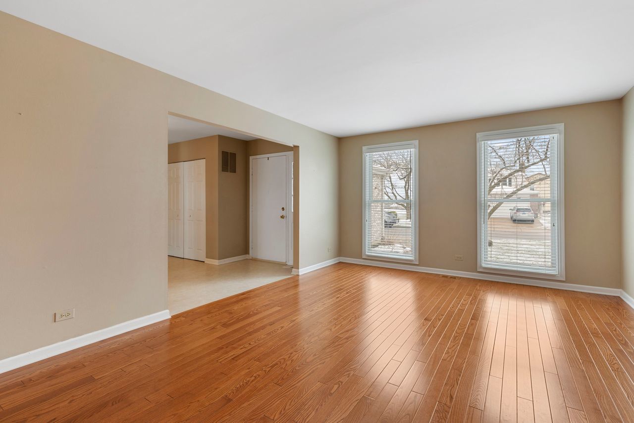681 Randi Lane Hoffman Estates, IL 60169 - Photo 9 of 33 an empty room with wooden floor and windows