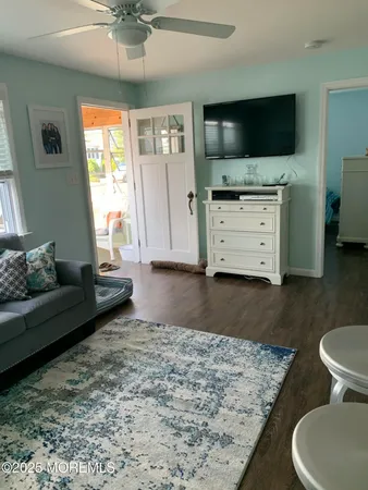 a living room with stainless steel appliances granite countertop furniture and wooden floor