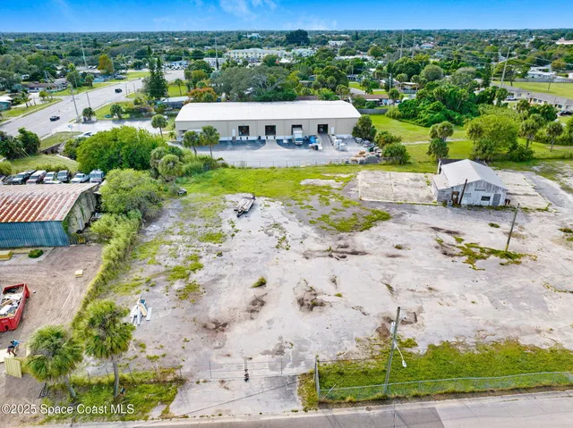 an aerial view of a city with lots of residential buildings and mountain view in back