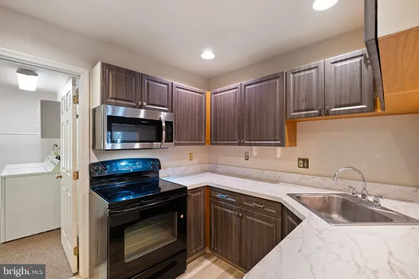 a kitchen with stainless steel appliances granite countertop a sink stove and microwave