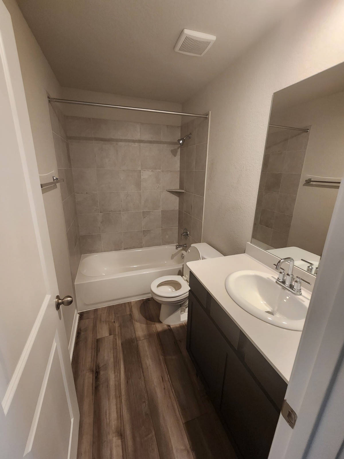 623 Sungrove Trail Georgetown, TX 78628 - Photo 10 of 17 Bathroom featuring vanity, dark wood-style floors, and washtub / shower combination