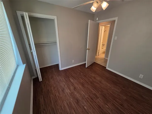 an empty room with wooden floor and a window