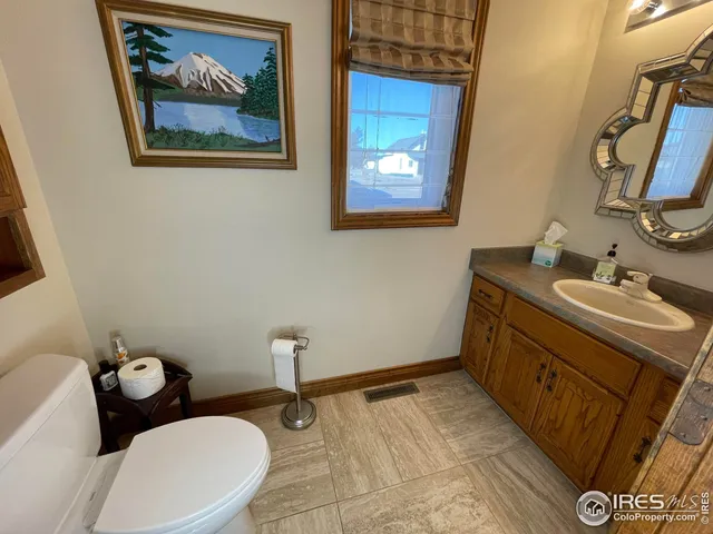 a bathroom with a granite countertop sink mirror vanity and toilet