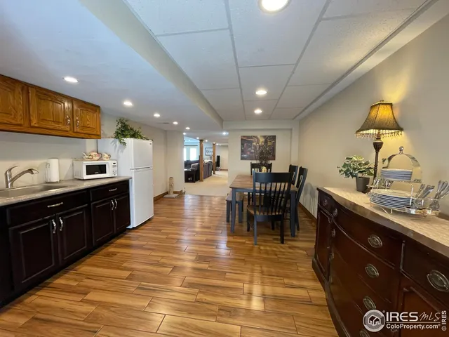 a kitchen with stainless steel appliances granite countertop sink wooden cabinets dining table and chairs