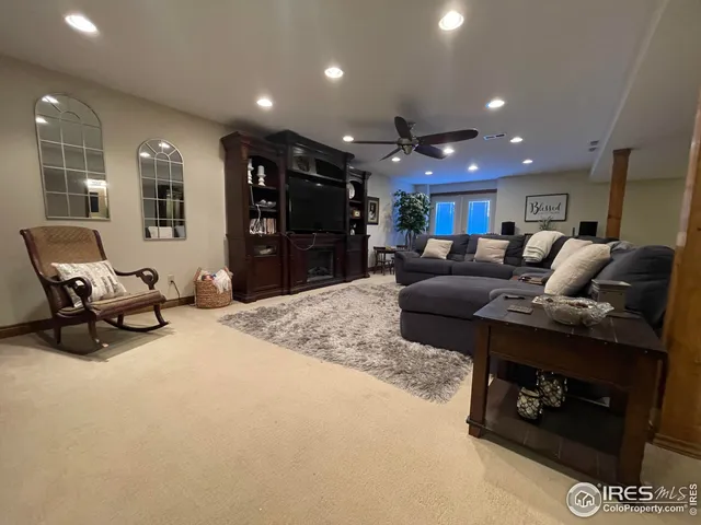 a living room with furniture a large window and a flat screen tv