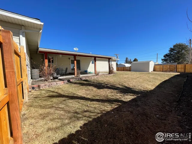 a view of a house with backyard and sitting area