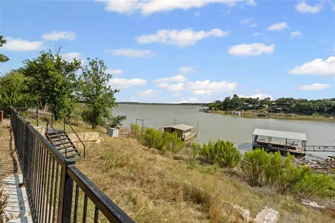an aerial view of a house with a yard and lake view