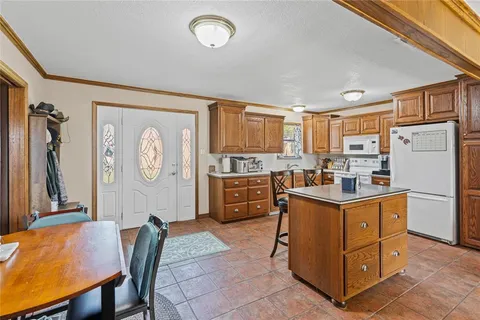 a kitchen with stainless steel appliances granite countertop a refrigerator a stove top oven a sink dishwasher and white cabinets