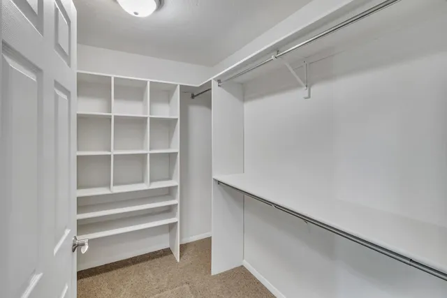 a view of walk in closet with empty racks