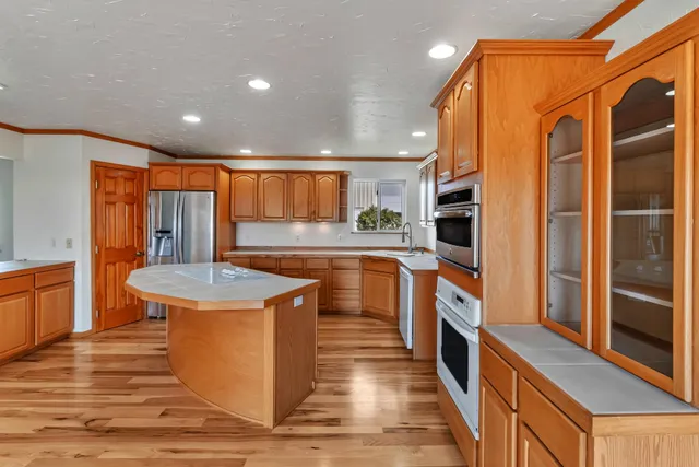 a kitchen with stainless steel appliances granite countertop a stove a sink and a refrigerator