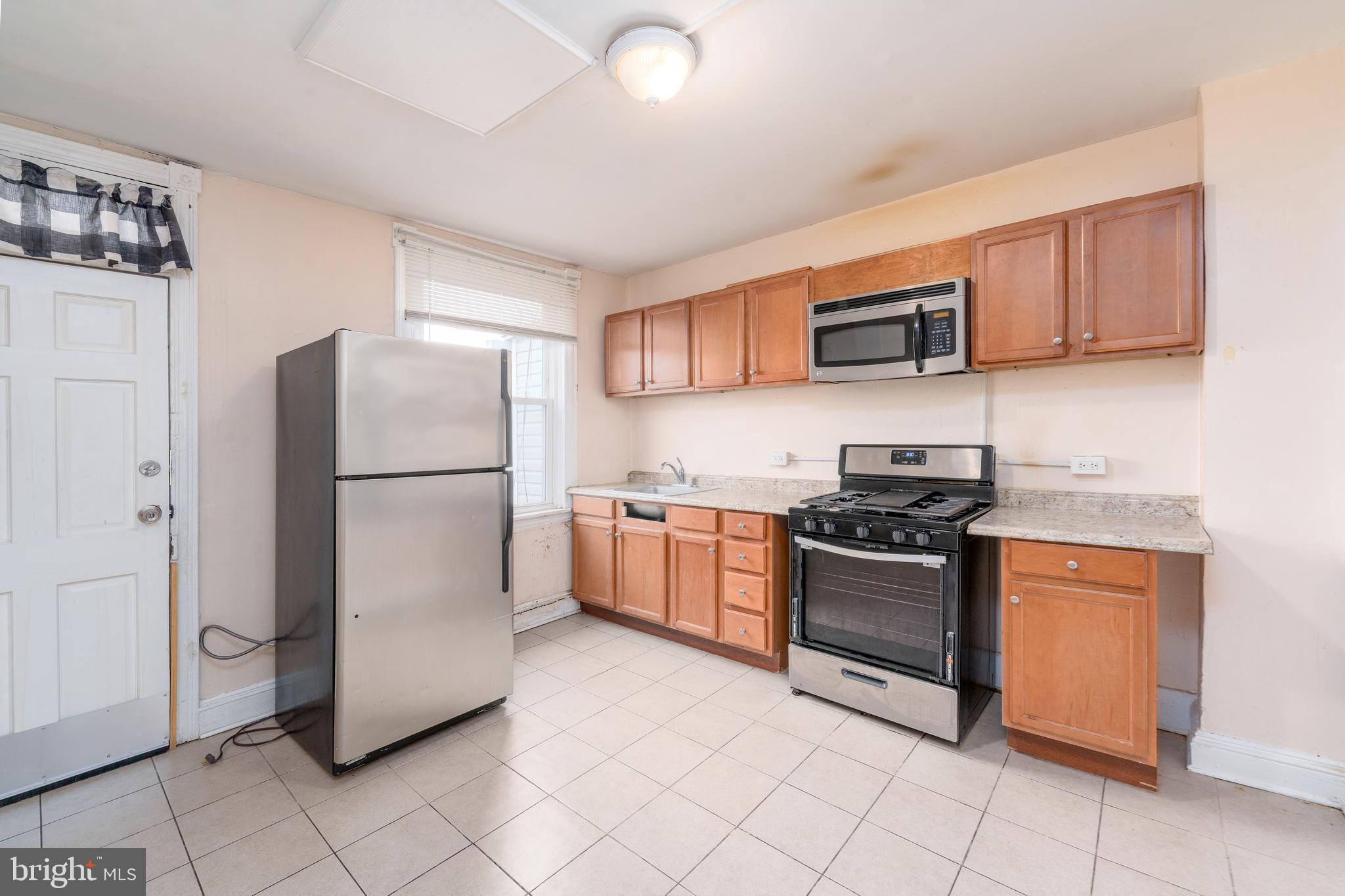 514 Brunswick Street Baltimore, MD 21223 - Photo 11 of 26 a kitchen with stainless steel appliances granite countertop a refrigerator sink and stove