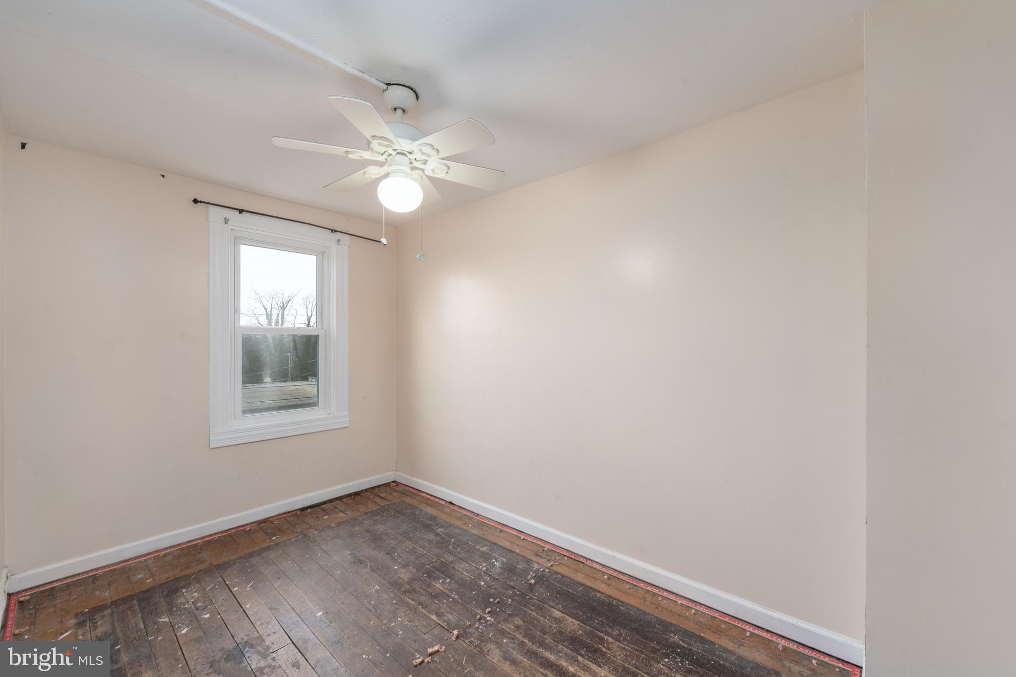 514 Brunswick Street Baltimore, MD 21223 - Photo 15 of 26 an empty room with a window and ceiling fan