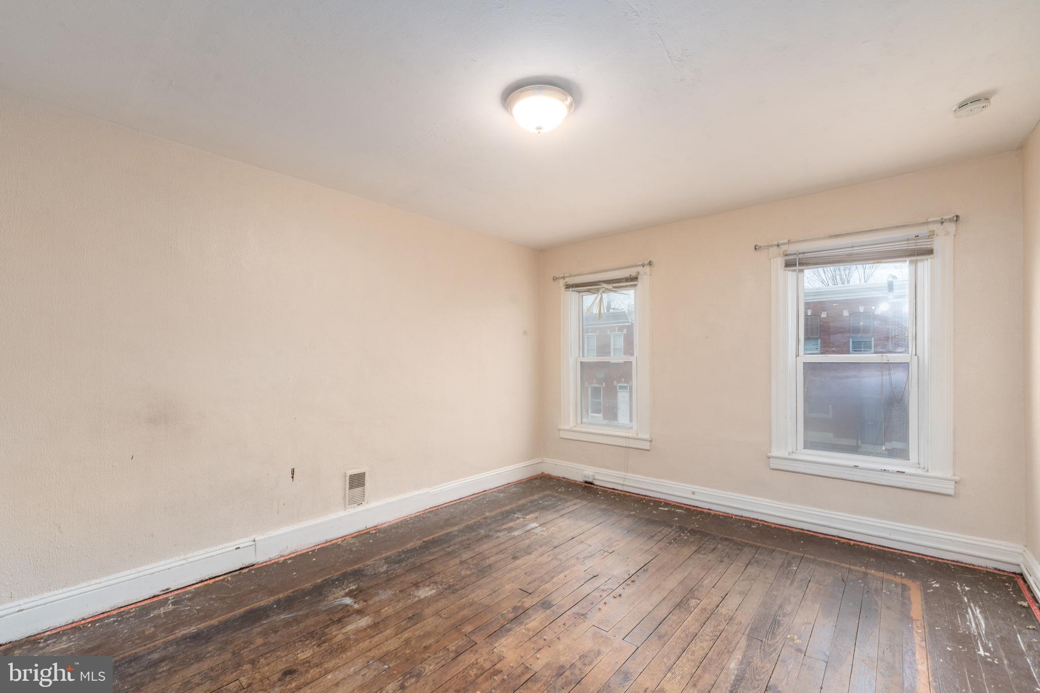 514 Brunswick Street Baltimore, MD 21223 - Photo 20 of 26 an empty room with wooden floor and windows