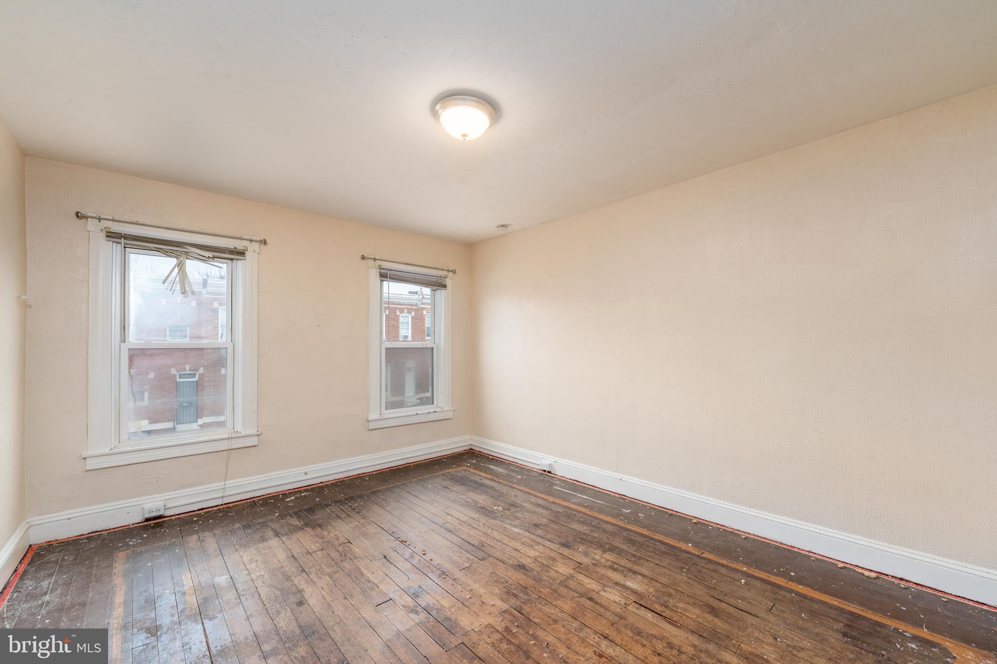514 Brunswick Street Baltimore, MD 21223 - Photo 22 of 26 an empty room with wooden floor and windows