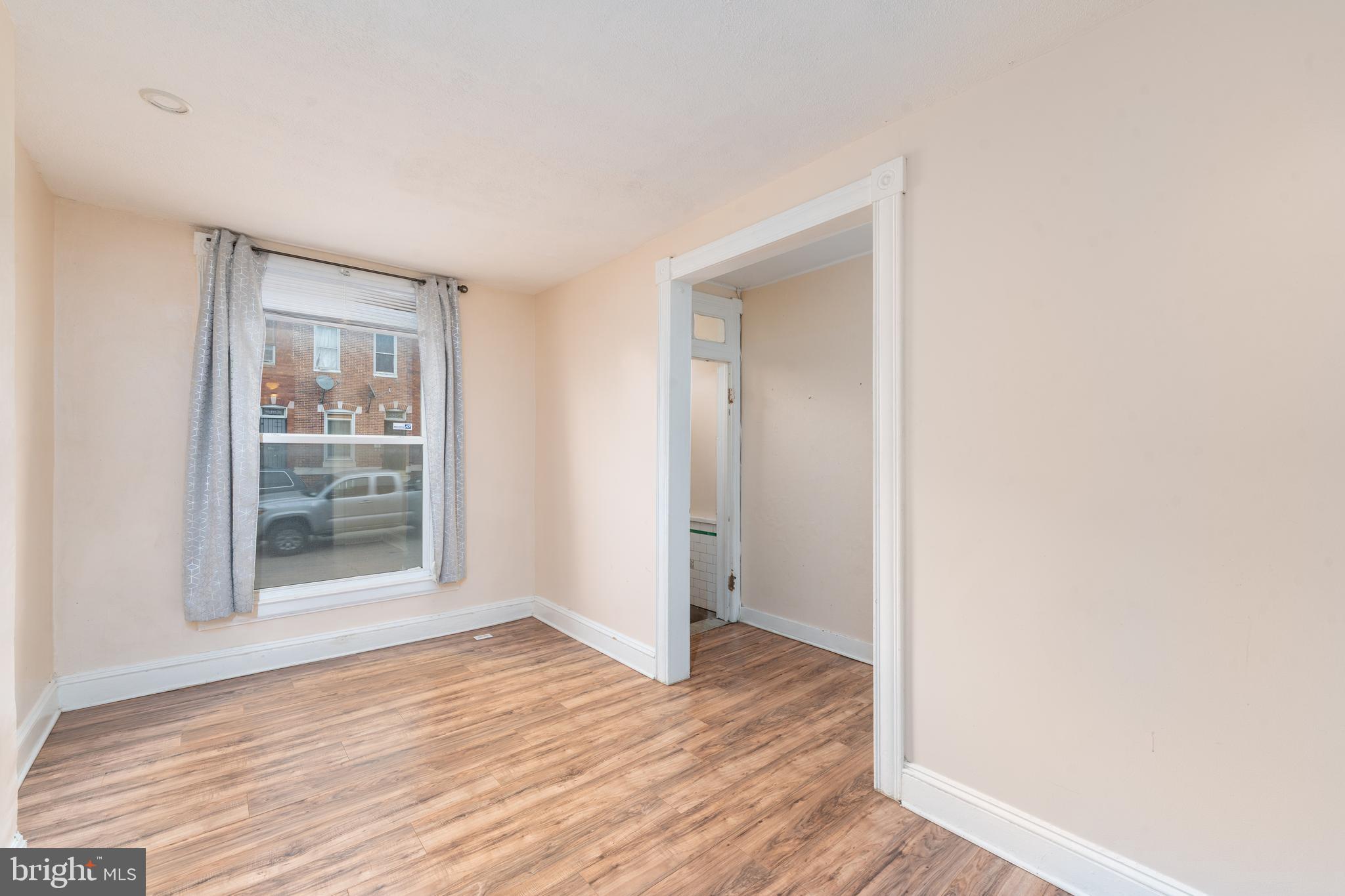 514 Brunswick Street Baltimore, MD 21223 - Photo 3 of 26 a view of an empty room with wooden floor and a window