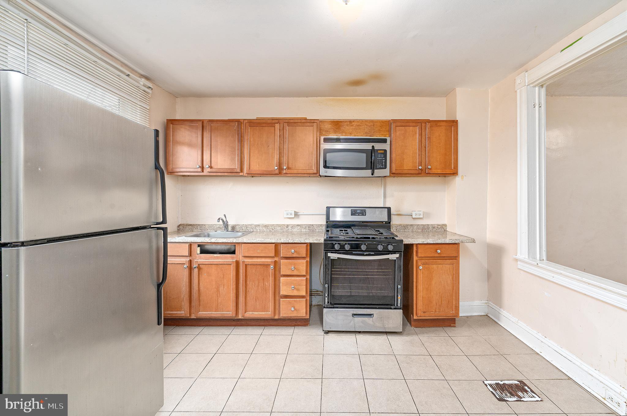 514 Brunswick Street Baltimore, MD 21223 - Photo 10 of 26 a kitchen with stainless steel appliances granite countertop a refrigerator stove and sink