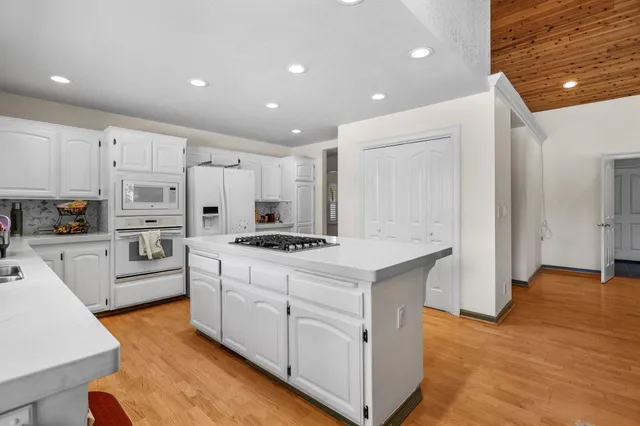 a kitchen with white cabinets and stainless steel appliances
