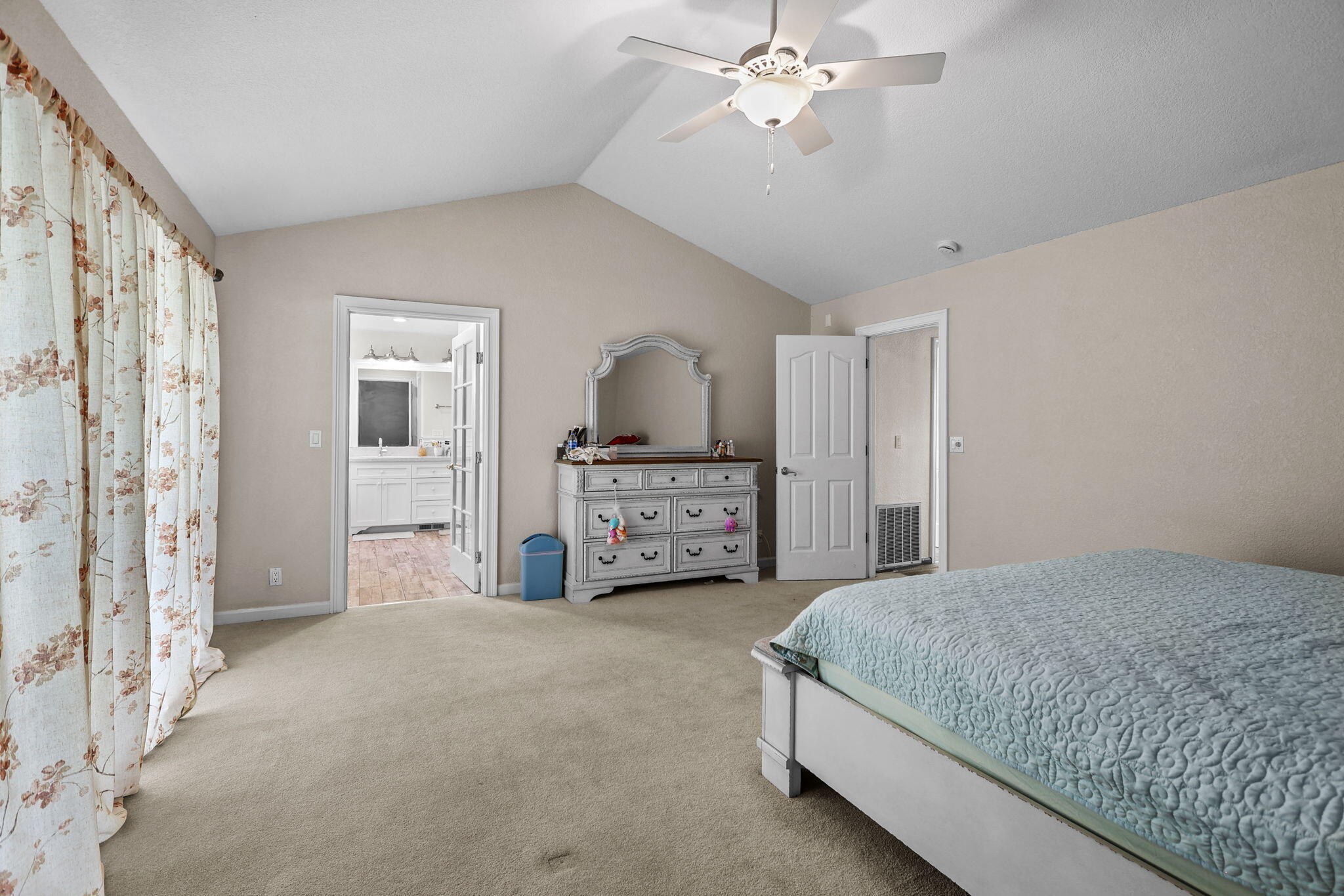 2366 Templeton Drive Redding, CA 96002 - Photo 21 of 54 a spacious bedroom with a bed and a chandelier