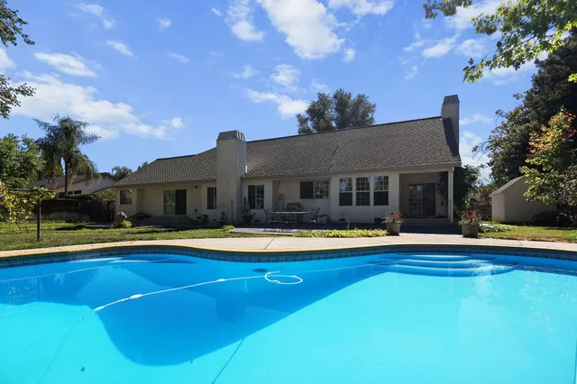 a view of a house with backyard and sitting area