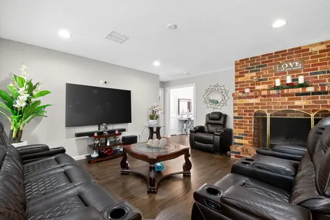 a living room with furniture a flat screen tv and a fireplace