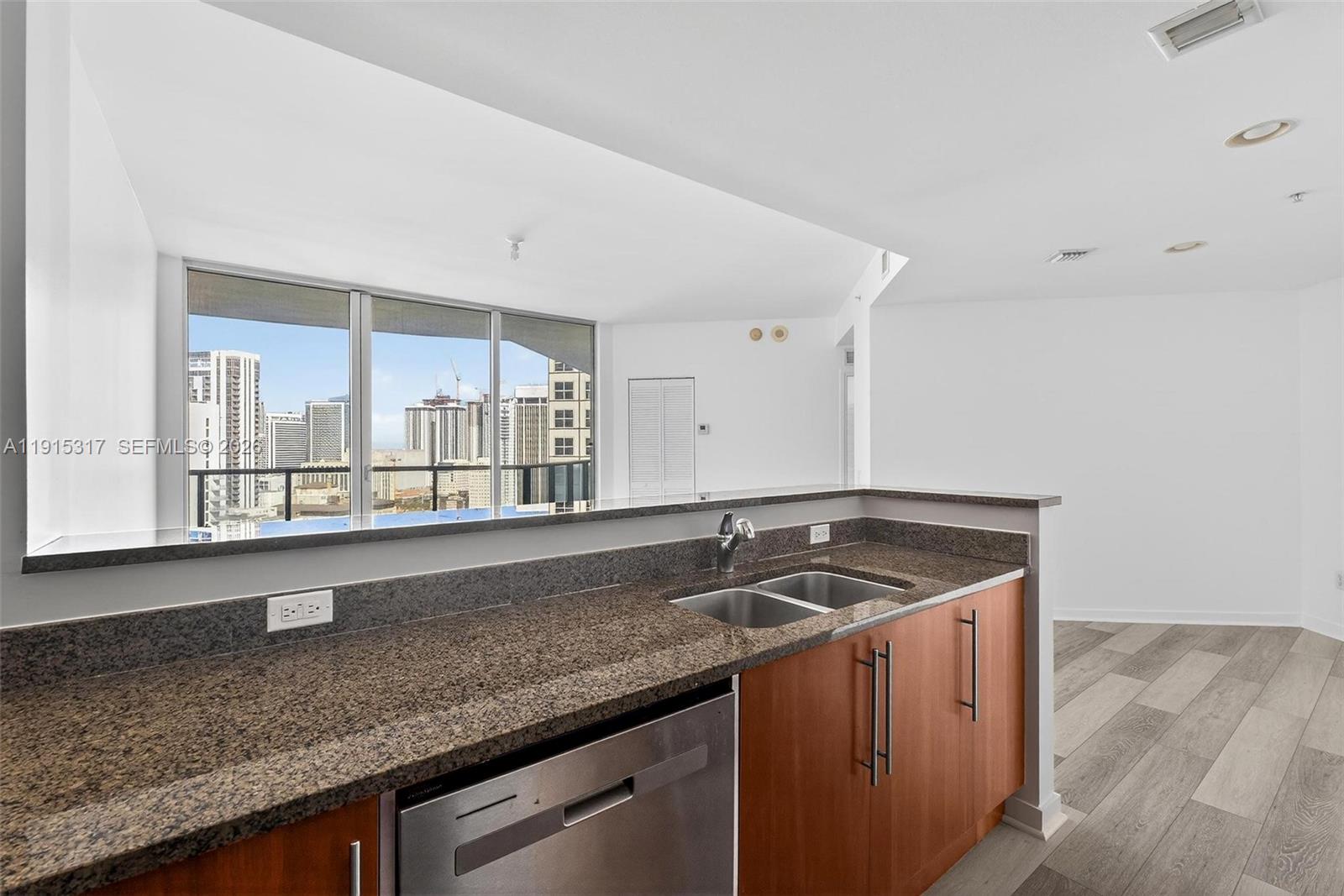 300 South Biscayne Boulevard, Unit T2407 Miami, FL 33131 - Photo 14 of 39 a kitchen with granite countertop a sink and a wooden cabinets