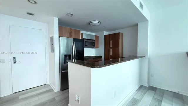 a kitchen with granite countertop a refrigerator and a sink
