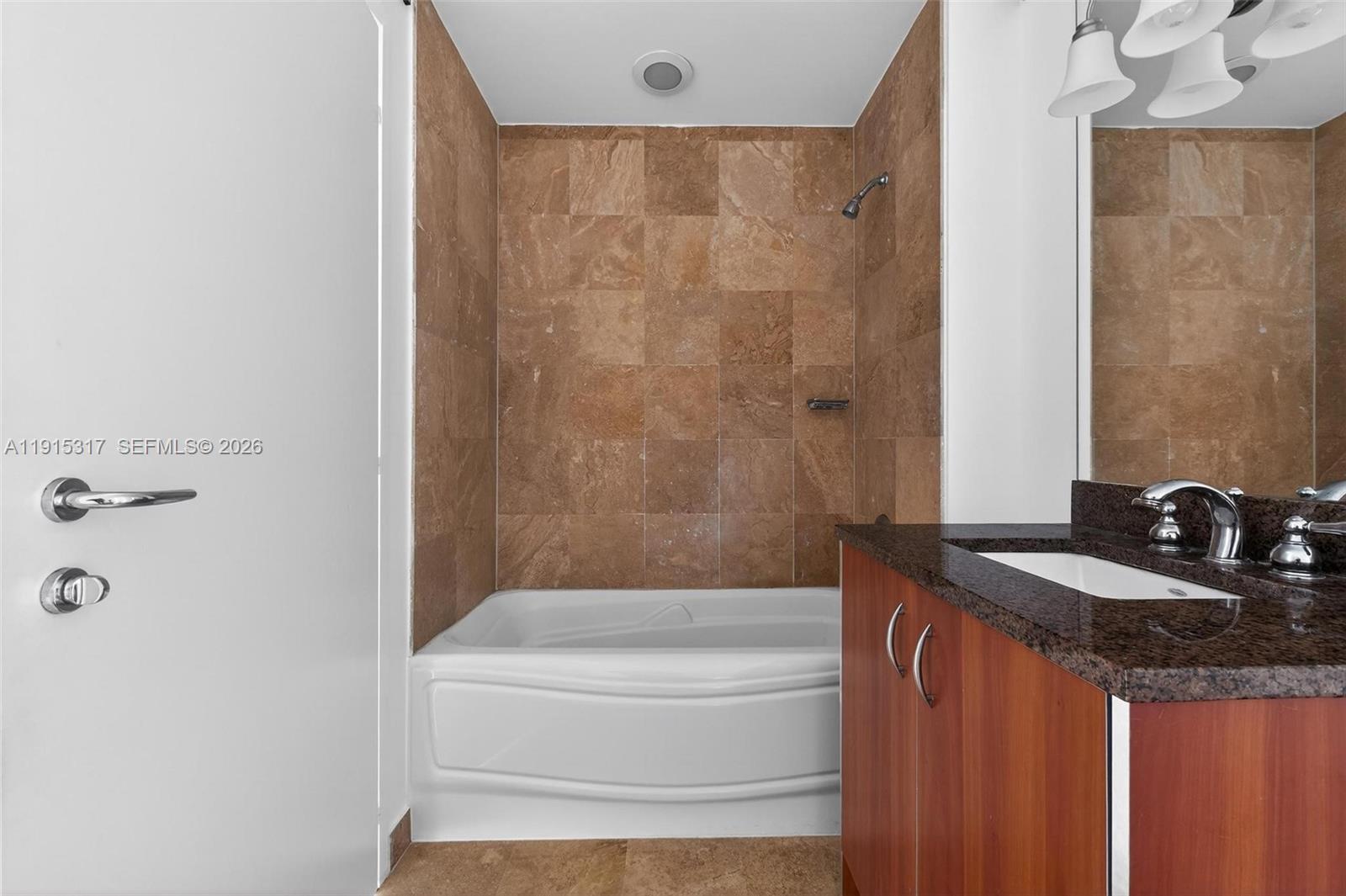 300 South Biscayne Boulevard, Unit T2407 Miami, FL 33131 - Photo 31 of 39 a bathroom with a granite countertop sink a toilet and bathtub