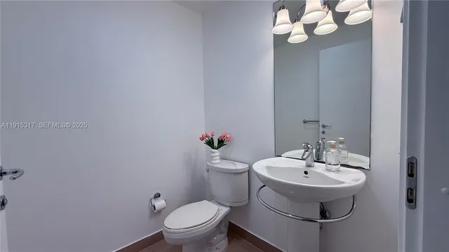 a bathroom with a sink mirror and toilet