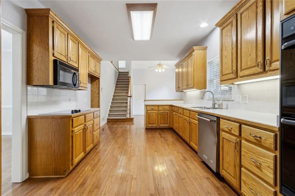 2651 West Rock Quarry Road Northeast Buford, GA 30519 - Photo 18 of 77 a large kitchen with stainless steel appliances granite countertop a stove a sink dishwasher and a microwave oven with wooden floor