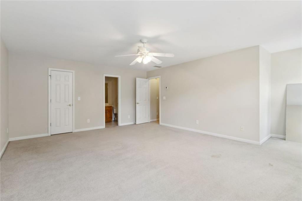 2651 West Rock Quarry Road Northeast Buford, GA 30519 - Photo 47 of 77 an empty room with a ceiling fan and a window