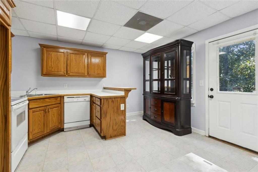 2651 West Rock Quarry Road Northeast Buford, GA 30519 - Photo 54 of 77 a utility room with stainless steel appliances granite countertop a stove a sink and a microwave