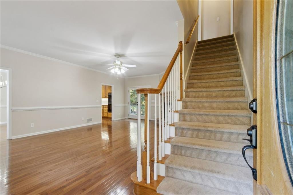 2651 West Rock Quarry Road Northeast Buford, GA 30519 - Photo 7 of 77 a view of a hallway with wooden floor and staircase