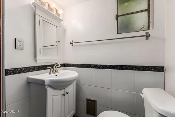 a bathroom with a sink mirror vanity and toilet