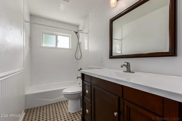a bathroom with a sink a toilet and a mirror