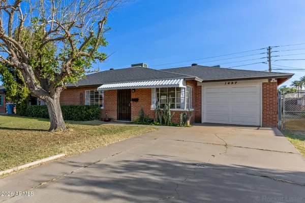 a front view of a house with a yard and a garage