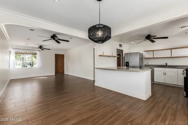 a view of a kitchen with a stove wooden floor and a ceiling fan