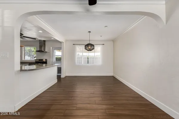 a view of an empty room with window and wooden floor