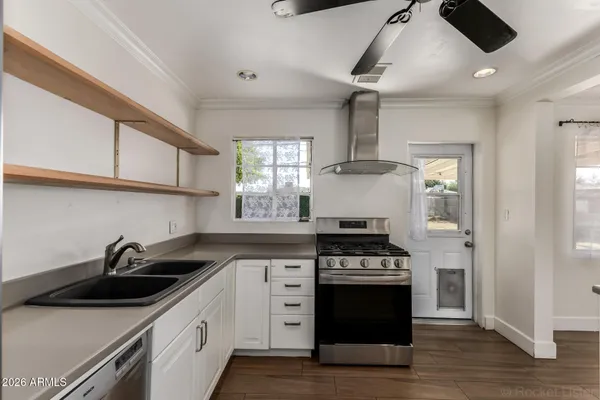 a kitchen with stainless steel appliances a sink a stove and cabinets