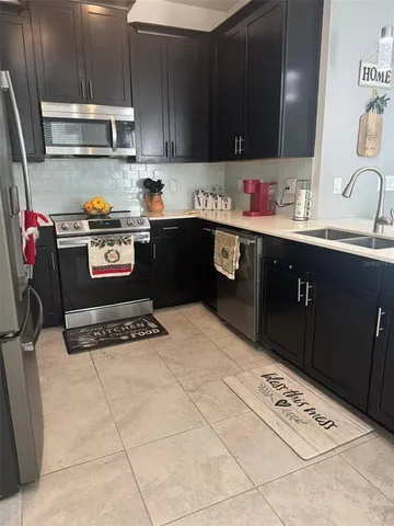 a kitchen with stainless steel appliances a sink stove and cabinets