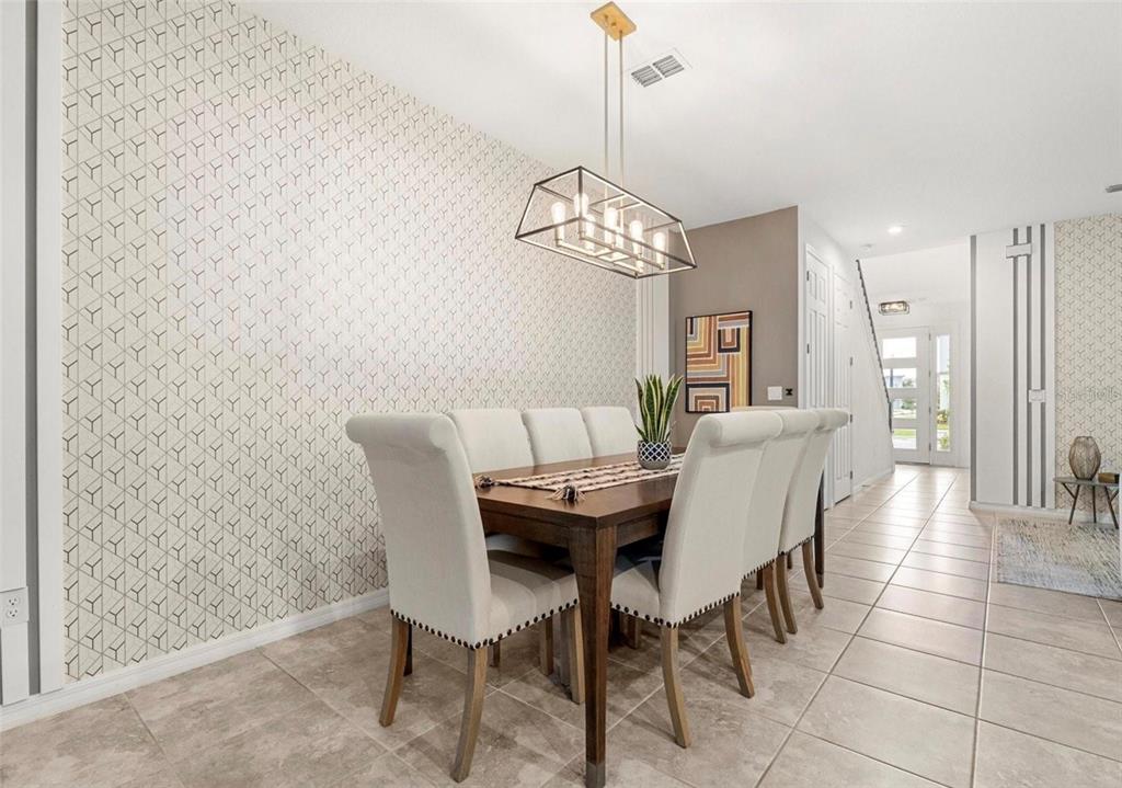 2163 Copper Bell Place Kissimmee, FL 34747 - Photo 13 of 41 a view of a dining room with furniture a chandelier and wooden floor