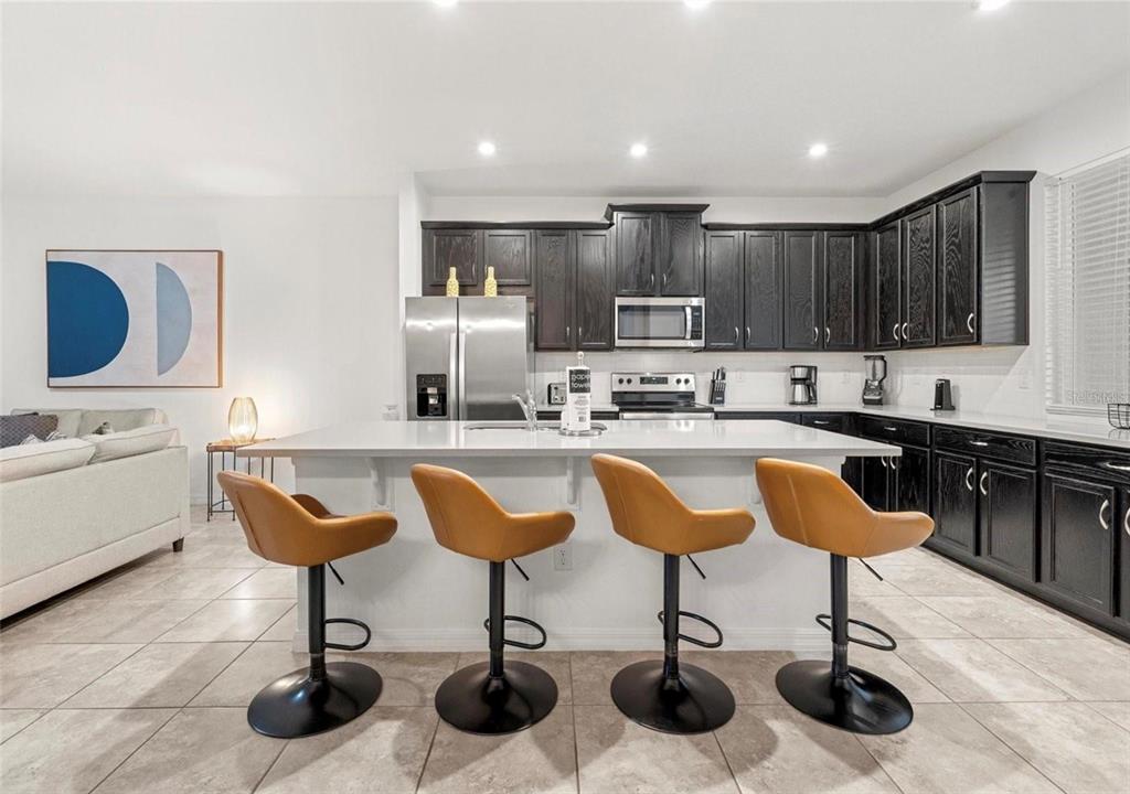 2163 Copper Bell Place Kissimmee, FL 34747 - Photo 20 of 41 a kitchen with granite countertop a counter space chairs stainless steel appliances and cabinets